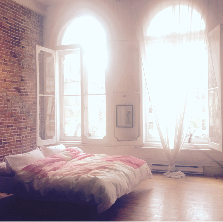 Soft-lit-bedroom-brick-wall-tall-windows-lots-of-light-with-ZayZay-So-Jess--duvet-cover-on-bed