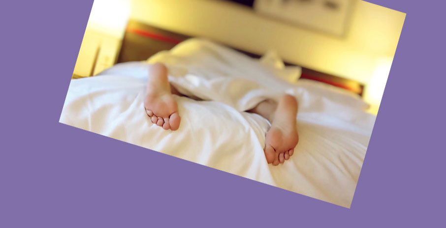 Rest-recovery-sleeping-in-bed-feet-exposed-on-purple-background